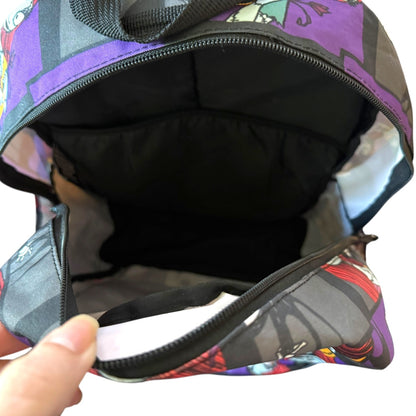 Colorful patterned bag with a hand holding it open, showing black interior.
