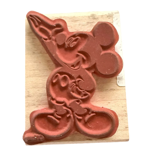 Red rubber stamp with a design on a wooden block