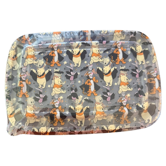 A container with rounded corners, featuring a repeating pattern of Winnie the Pooh, Piglet and Tigger in Halloween costumes on a dark gray background.