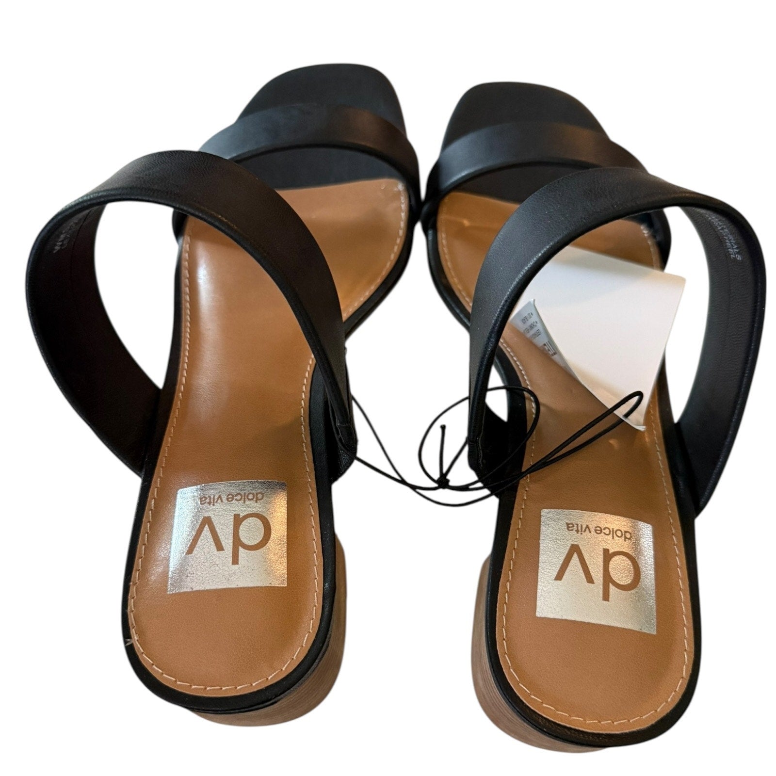 Pair of black sandals with tan soles on a white background