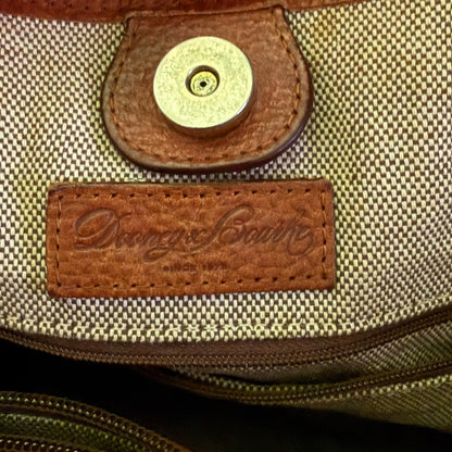 Close-up of a bag with a brown leather label featuring a brand name.
