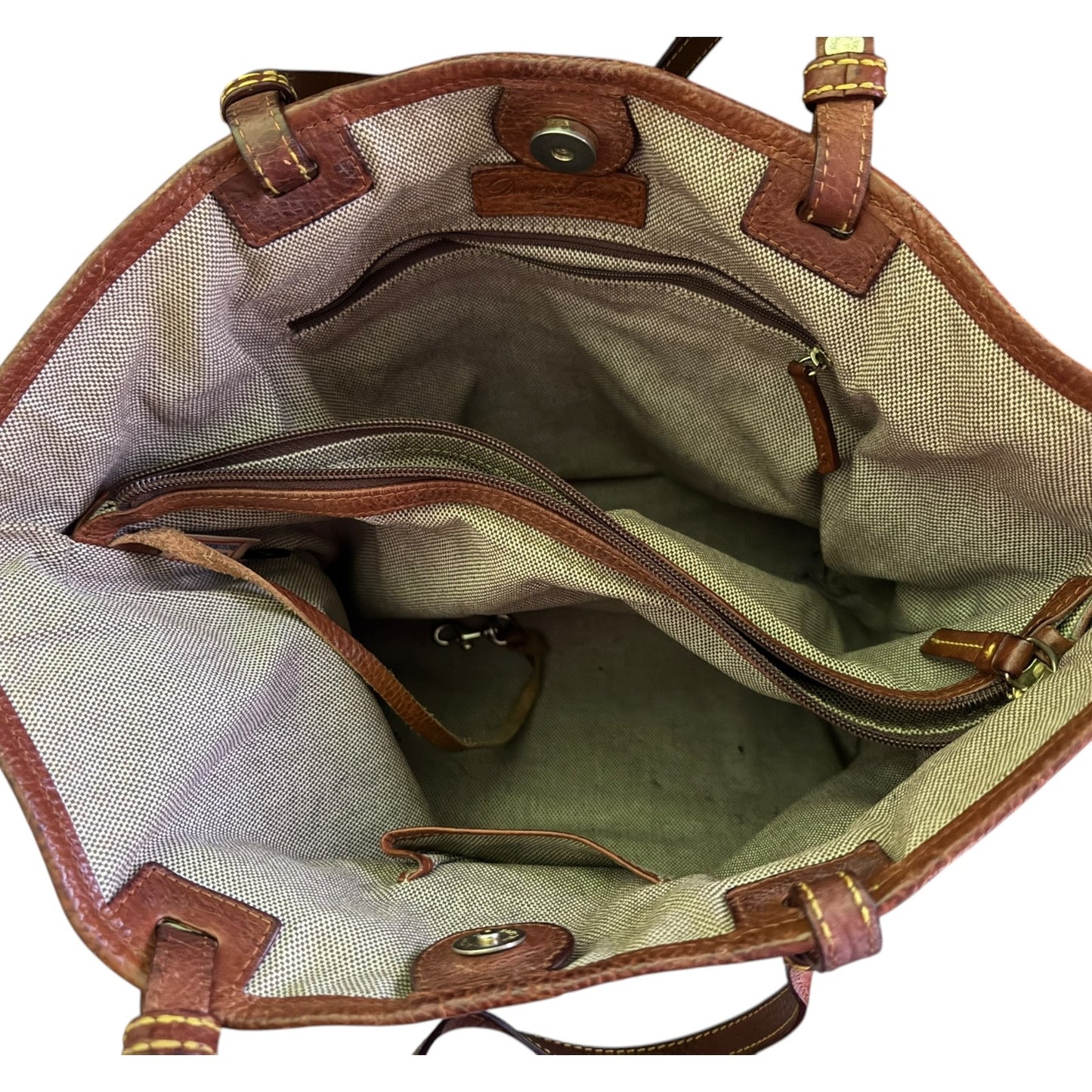 Open handbag with brown leather accents on a white background