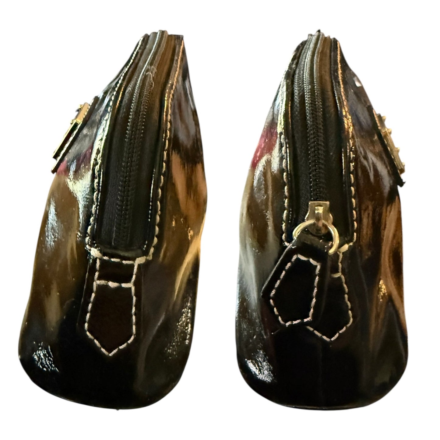 Black patent leather bag with decorative elements on a white background