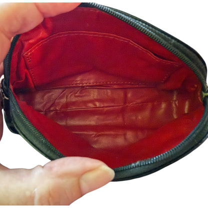 Interior with Red leather pouch held open by a hand on a white background