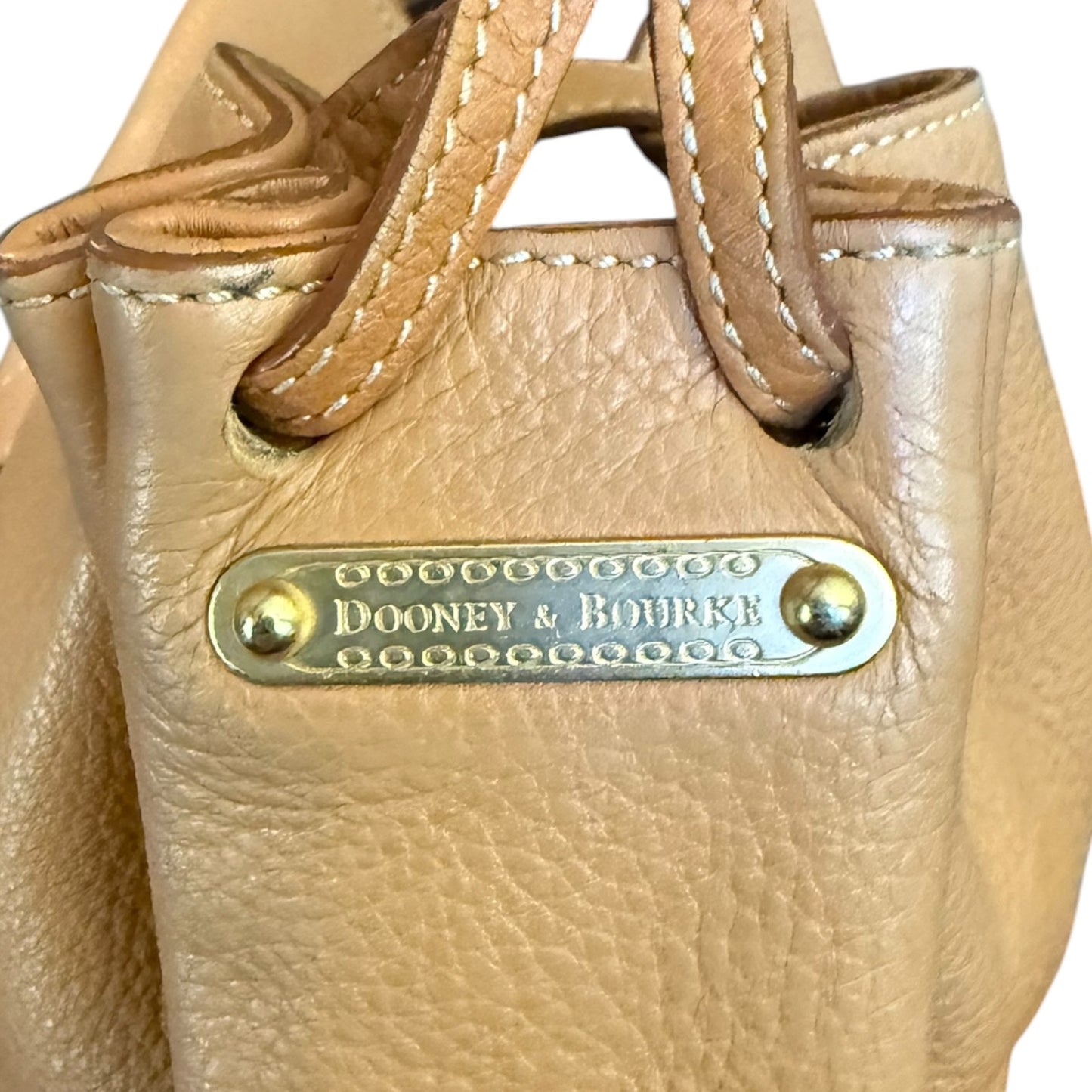 Leather handbag with 'Dooney & Bourke' label on a white background