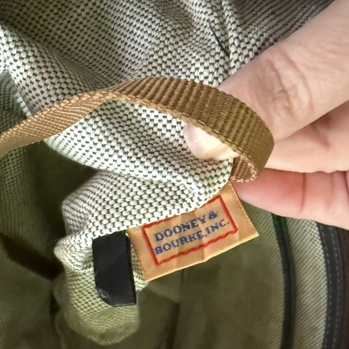 Close-up of a Dooney & Bourke Inc. label on a fabric background