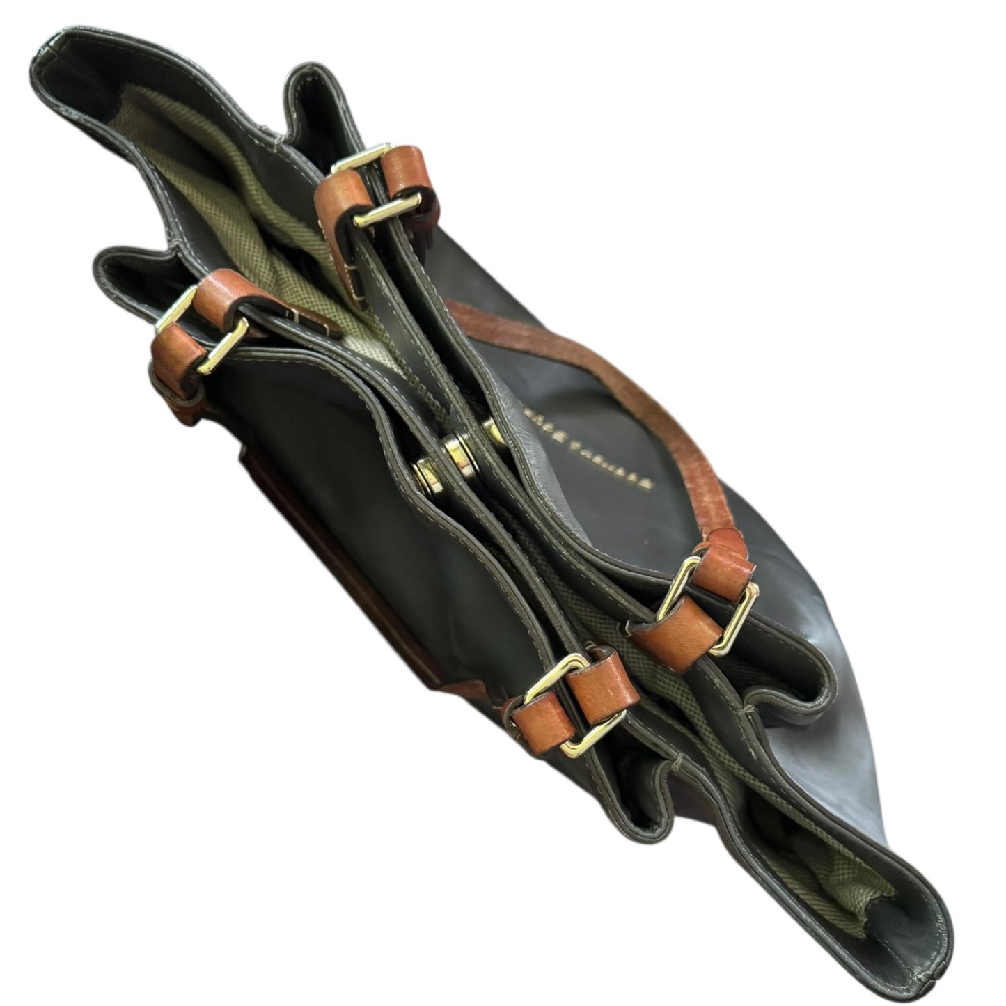 Top view of gray handbag with brown straps and gold buckles on a white background
