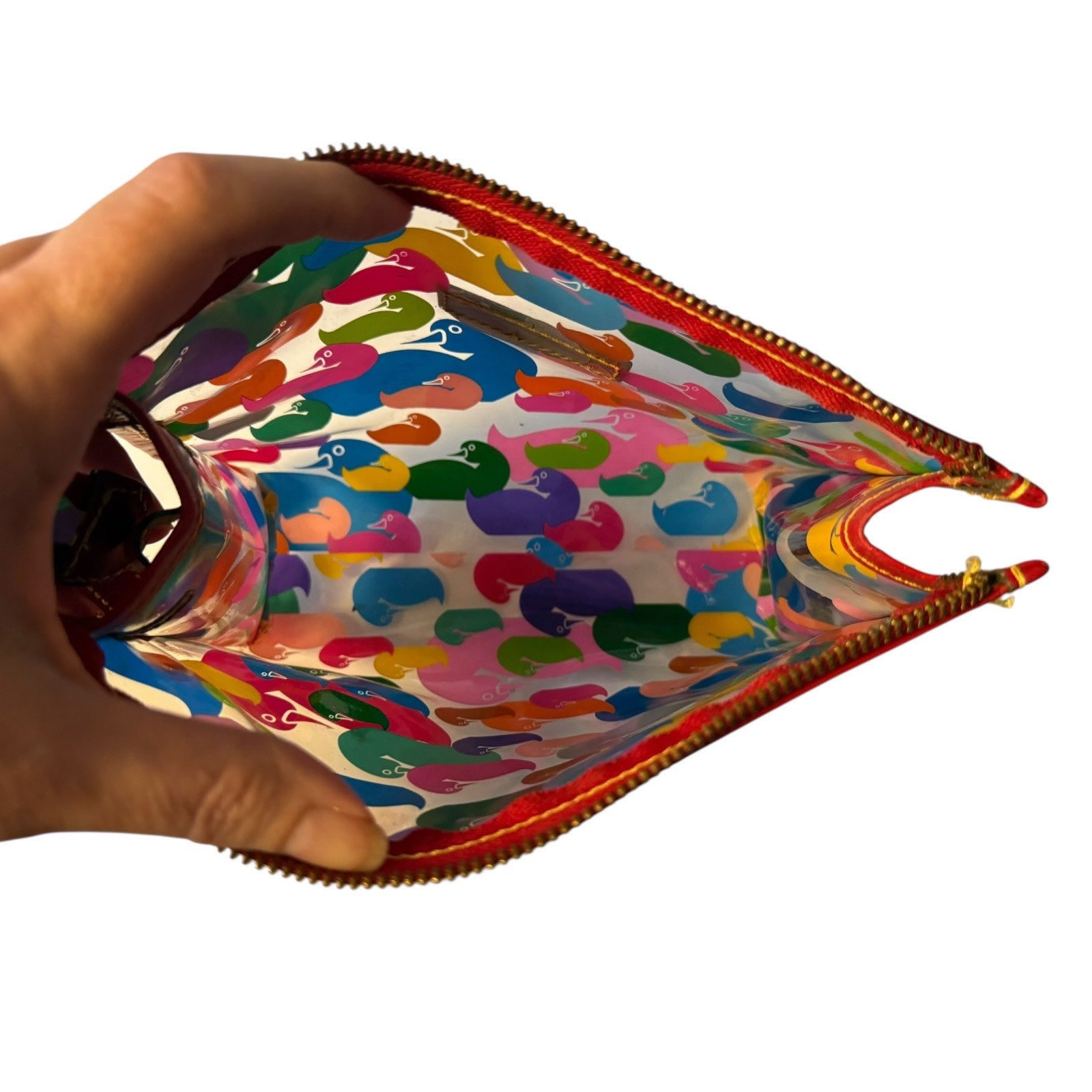 Interior of Colorful patterned pouch with a hand holding a bottle inside, on a white background