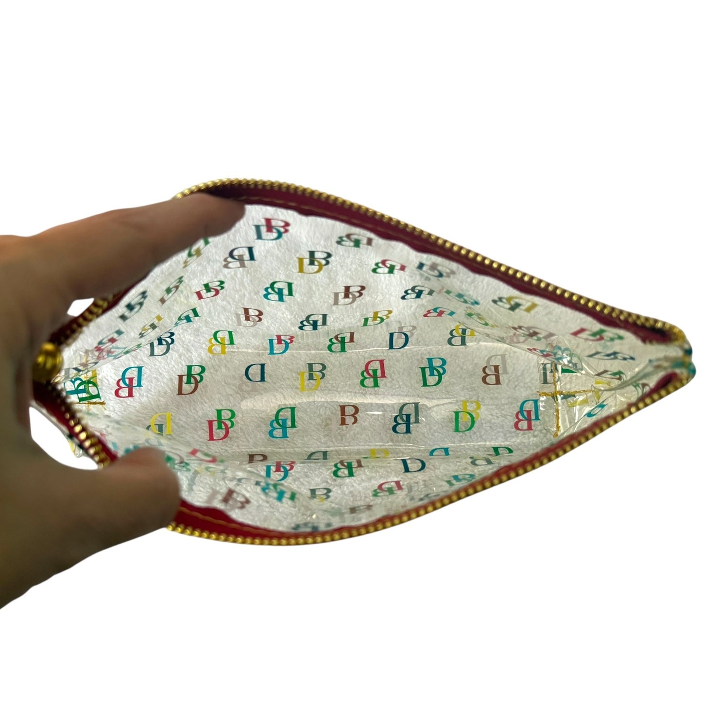 Hand holding a small pouch open with colorful letter pattern on a white background