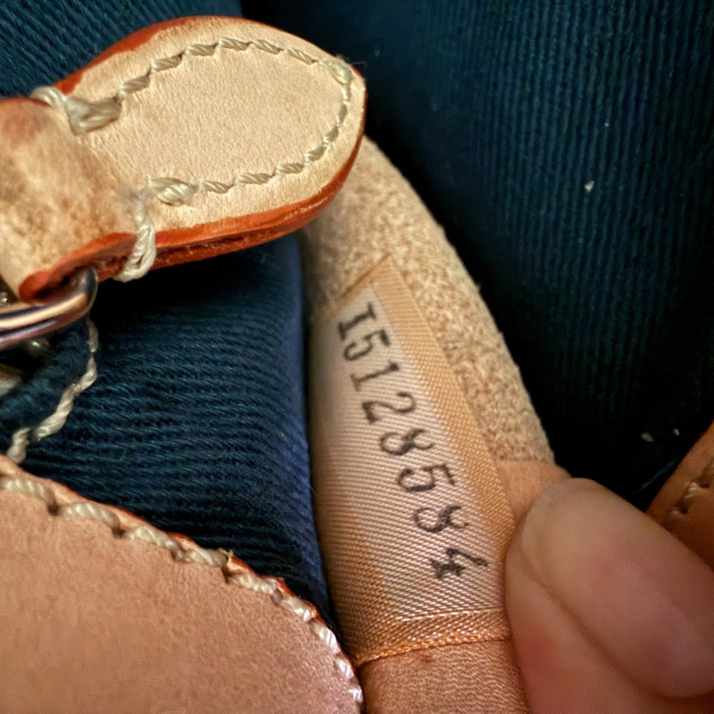 Close-up of a leather product with a visible serial number tag.