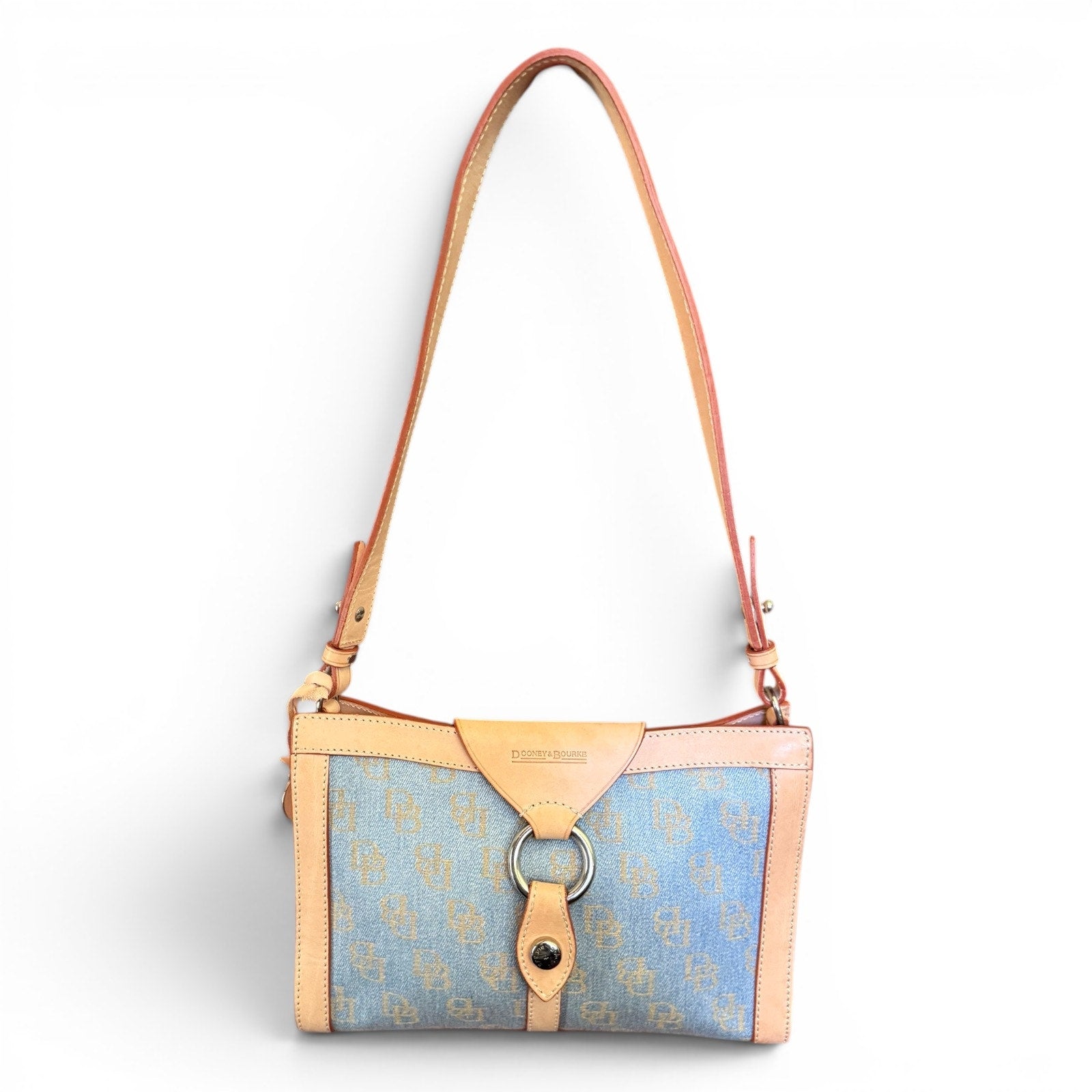 Handbag with blue patterned fabric and tan leather accents on a white background