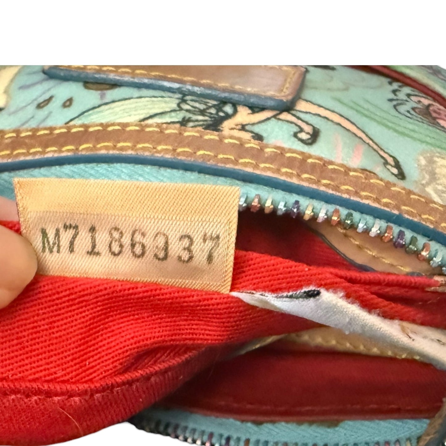 Serial number on tag from interior of Dooney & Bourke purse on a white background