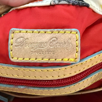 Close-up of a red bag with a 'Dooney & Bourke' label on a red background