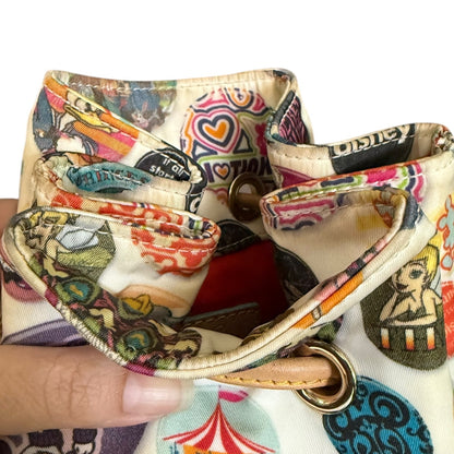 Colorful patterned handbag top closure  with a person's hand holding it.