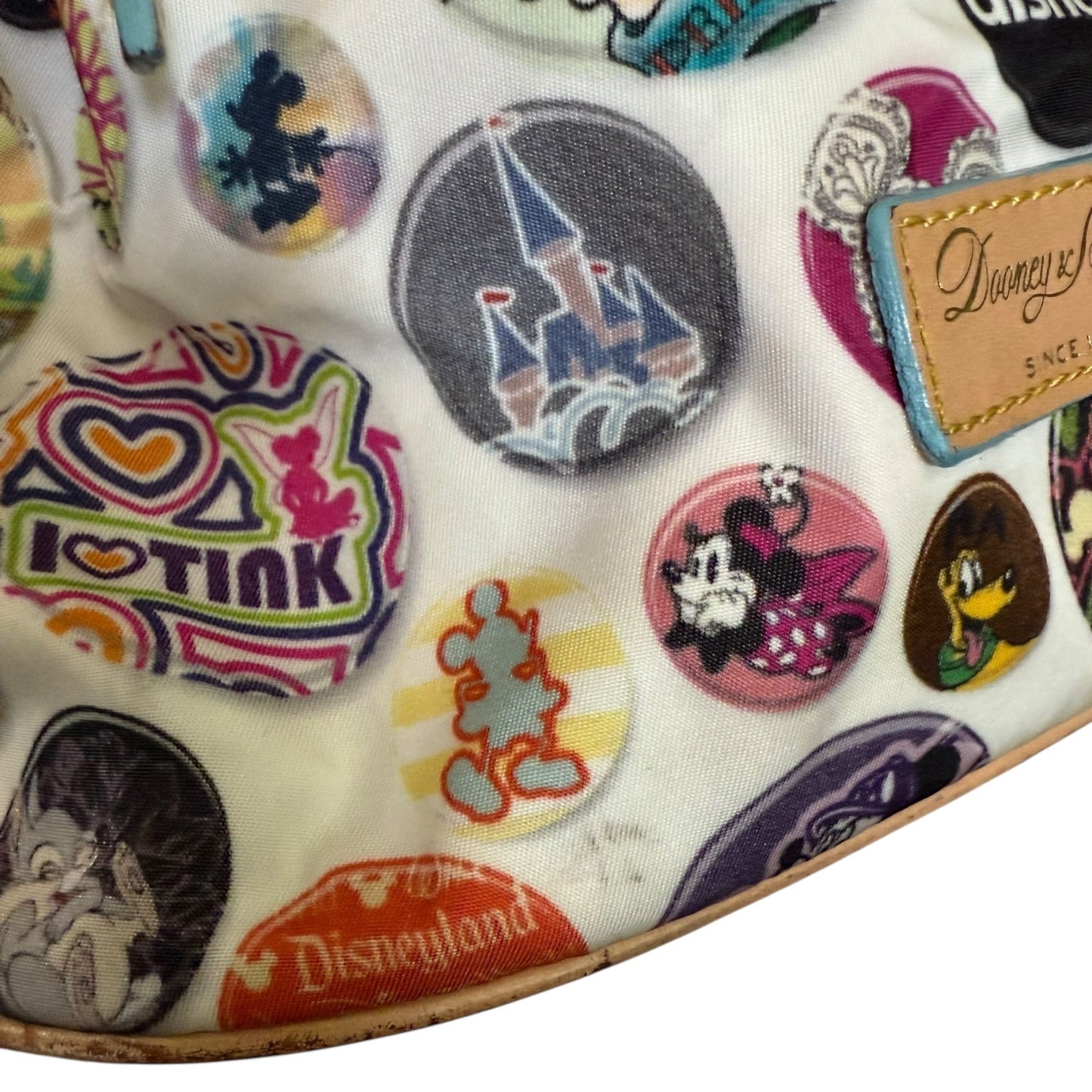 Disney-themed fabric with various characters and logos showing dirt and marks on a white background