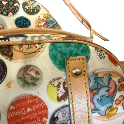 Colorful bag with cartoon character pattern and brown leather showing scuffs