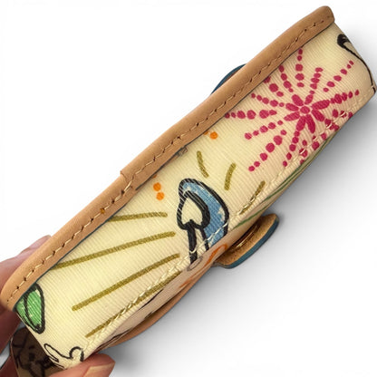 Bottom view of wristlet held by a hand on a white background