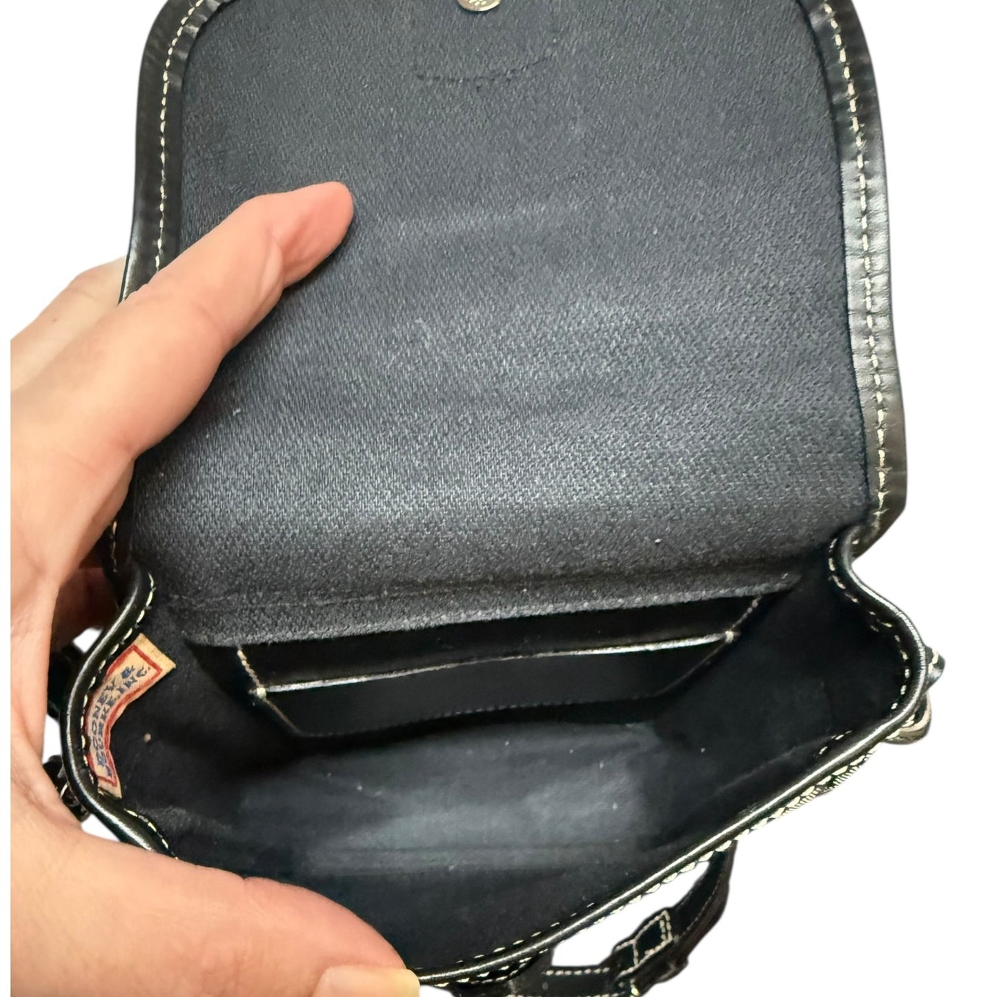 Hand holding a gray leather pouch showing interior with a white background