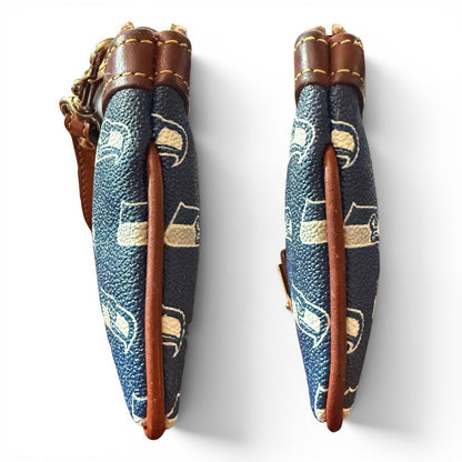 Side view of wristlet with blue fabric and brown leather accents on a white background