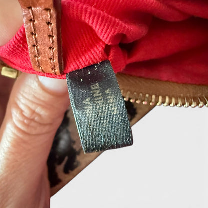 Close-up of a red lining with a made in  label held by a hand.