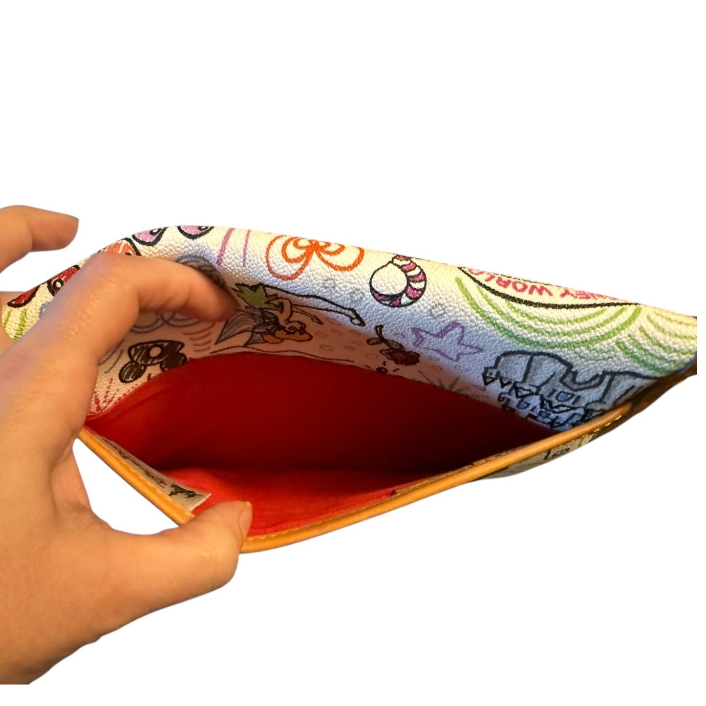 Colorful  pouch with a hand holding it open a back pocket on a white background