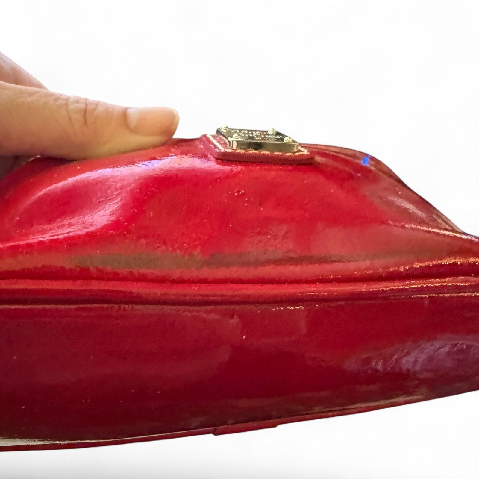 Red clutch bag with issues held by a hand on a white background