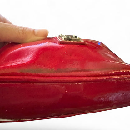 Red clutch bag with issues held by a hand on a white background