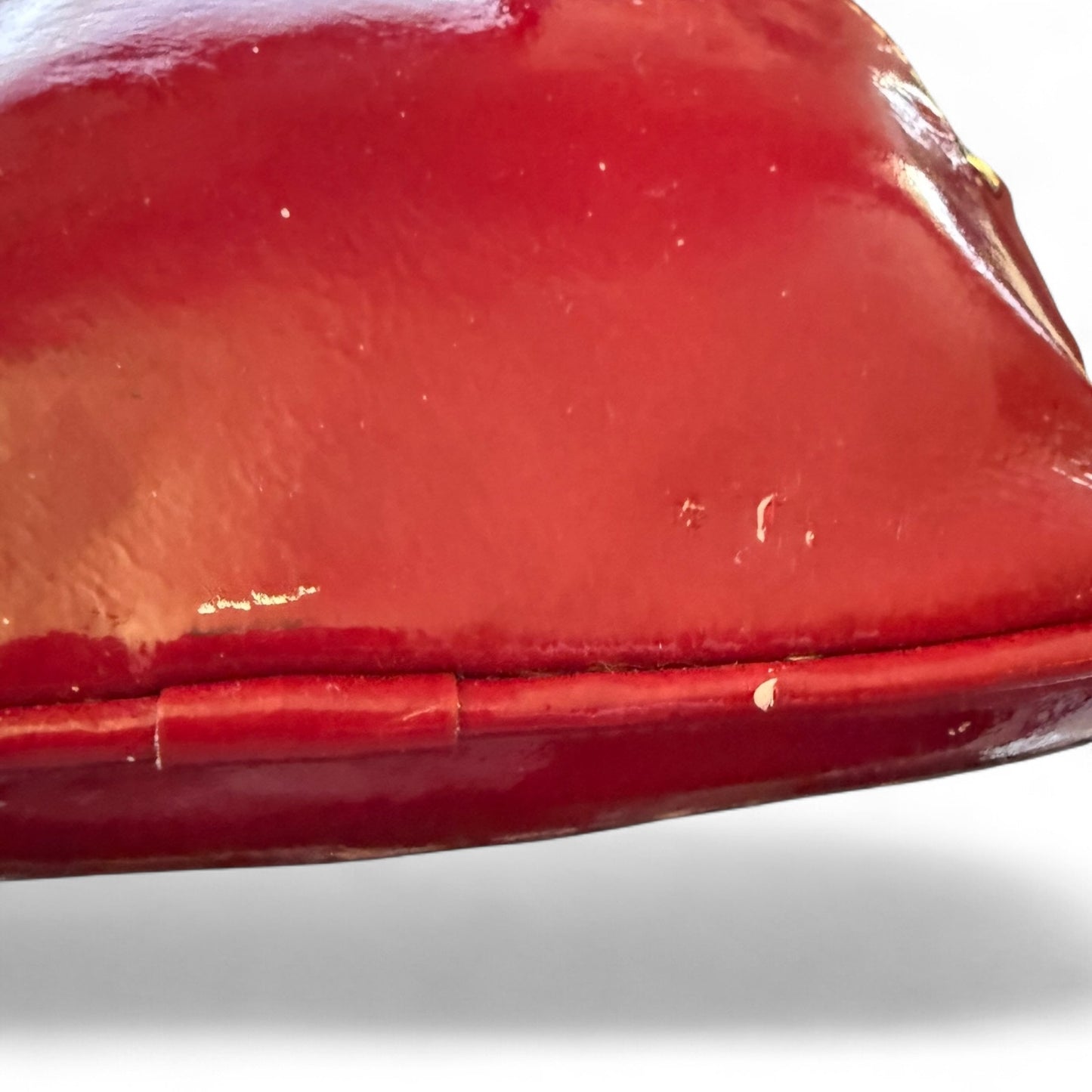 Close-up of a red pouch with issues on a white background