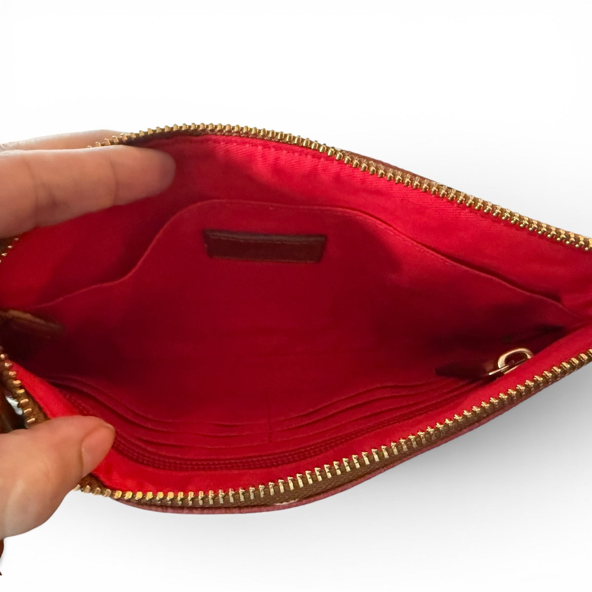 Red pouch interior with gold zipper on a white background