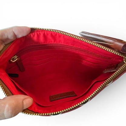 Red pouch interior showing pockets with gold zipper held open by a hand on a white background