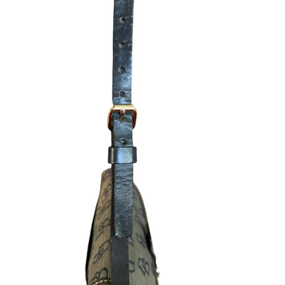 Close-up of a black strap with a gold buckle on a white background