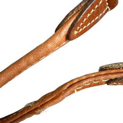 Close-up of brown leather strap repair with stitching on a white background