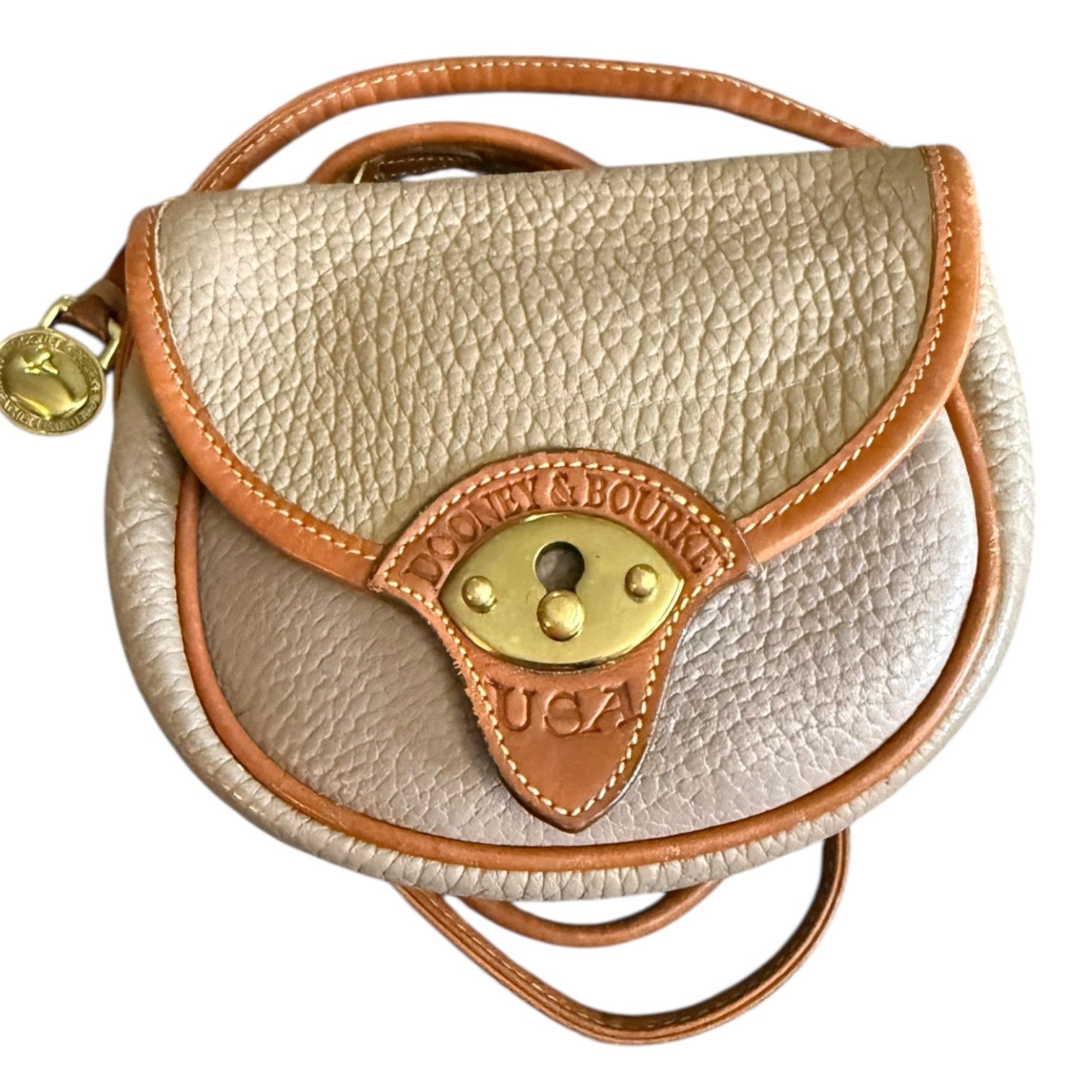 Beige leather handbag with brown accents and visible branding on a white background