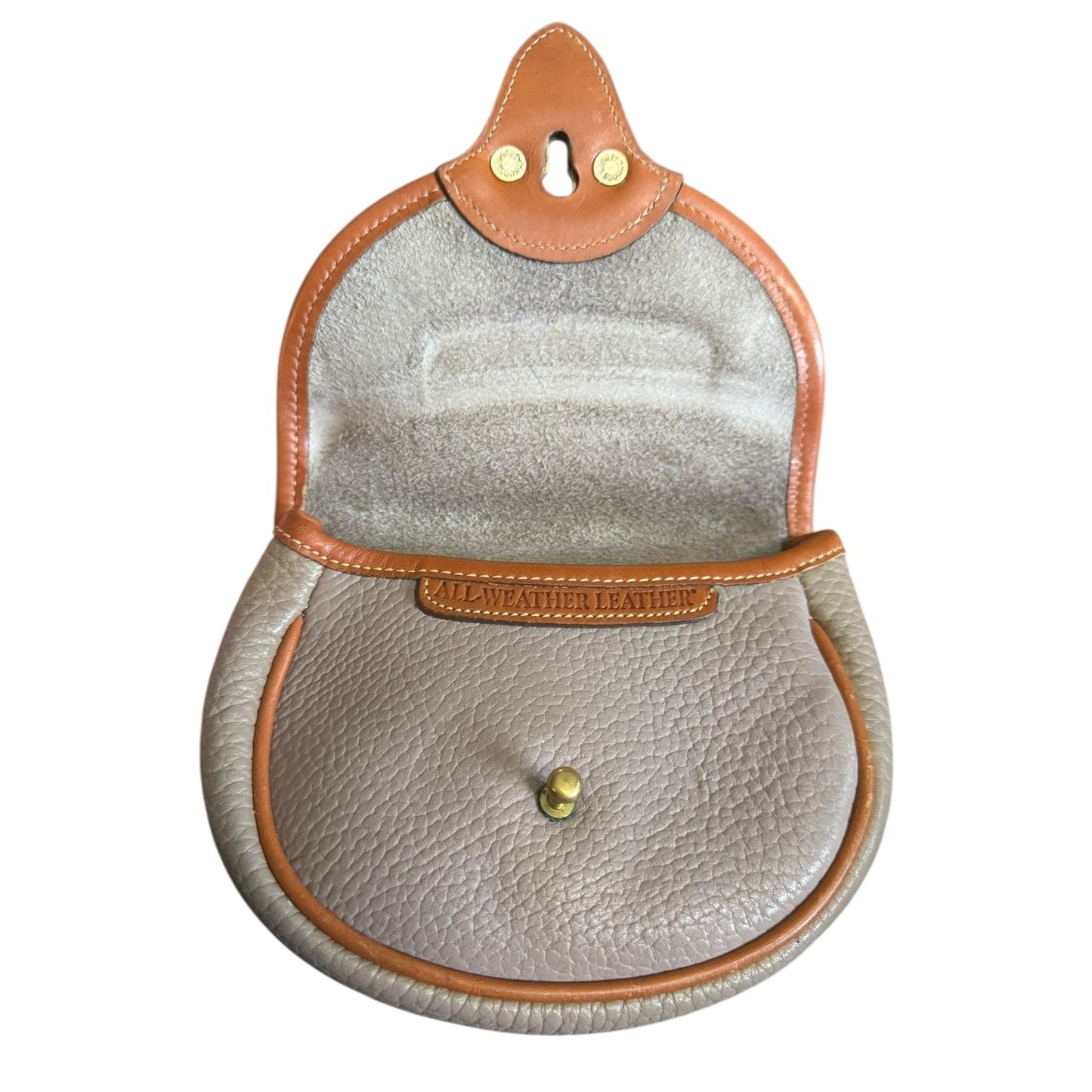 Interior of Round leather pouch with brown trim and visible brand name on a white background