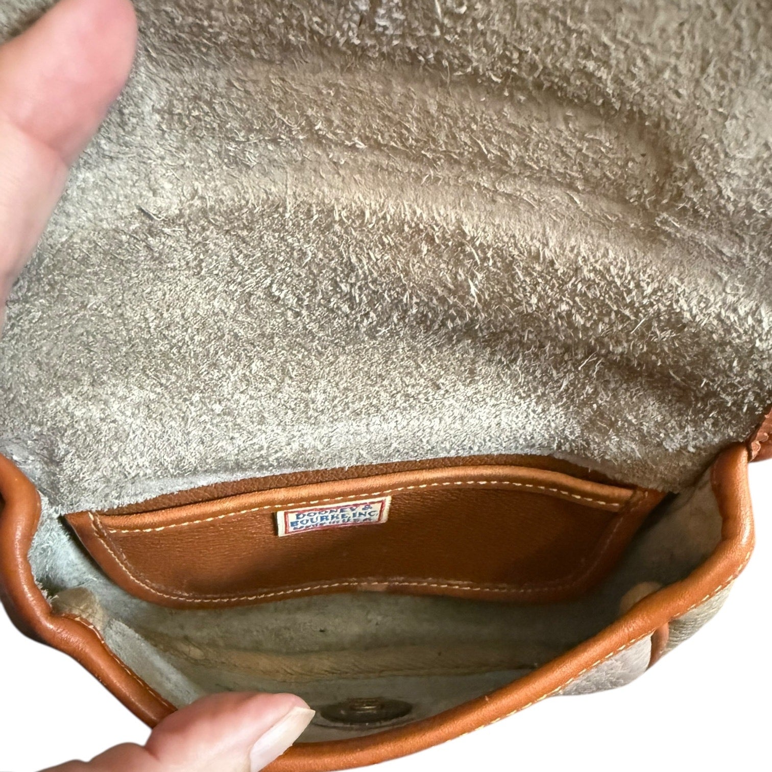 Close-up of a interior textured bag with a visible brand label.