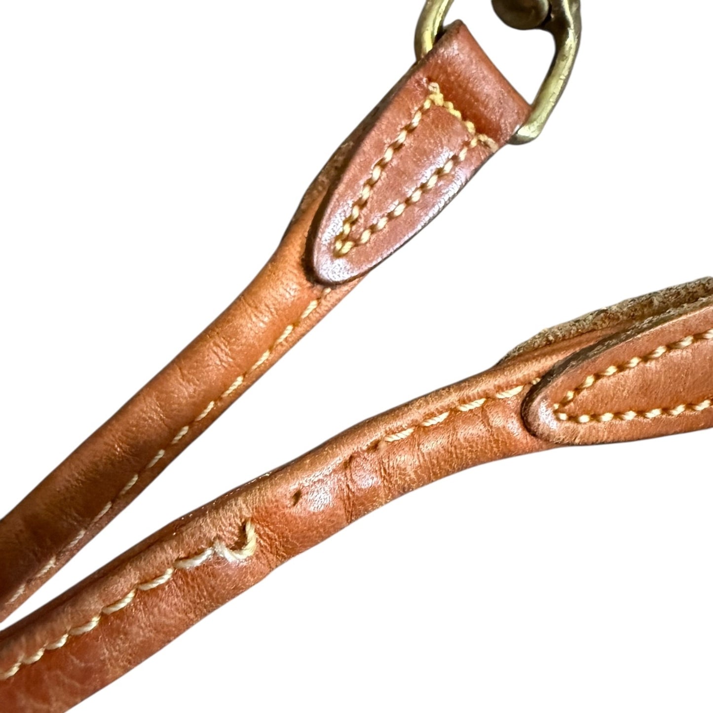Close-up of a brown leather strap with yellow stitching on a white background