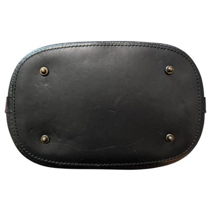 Black leather purse with metal studs on bottom on a white background