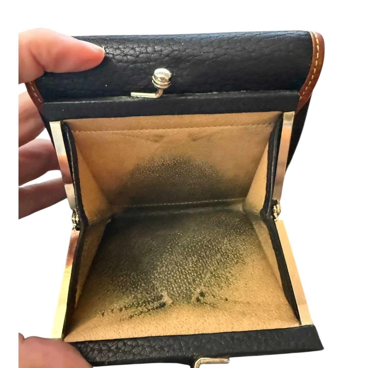 Open black leather wallet with gold interior, held by a hand.