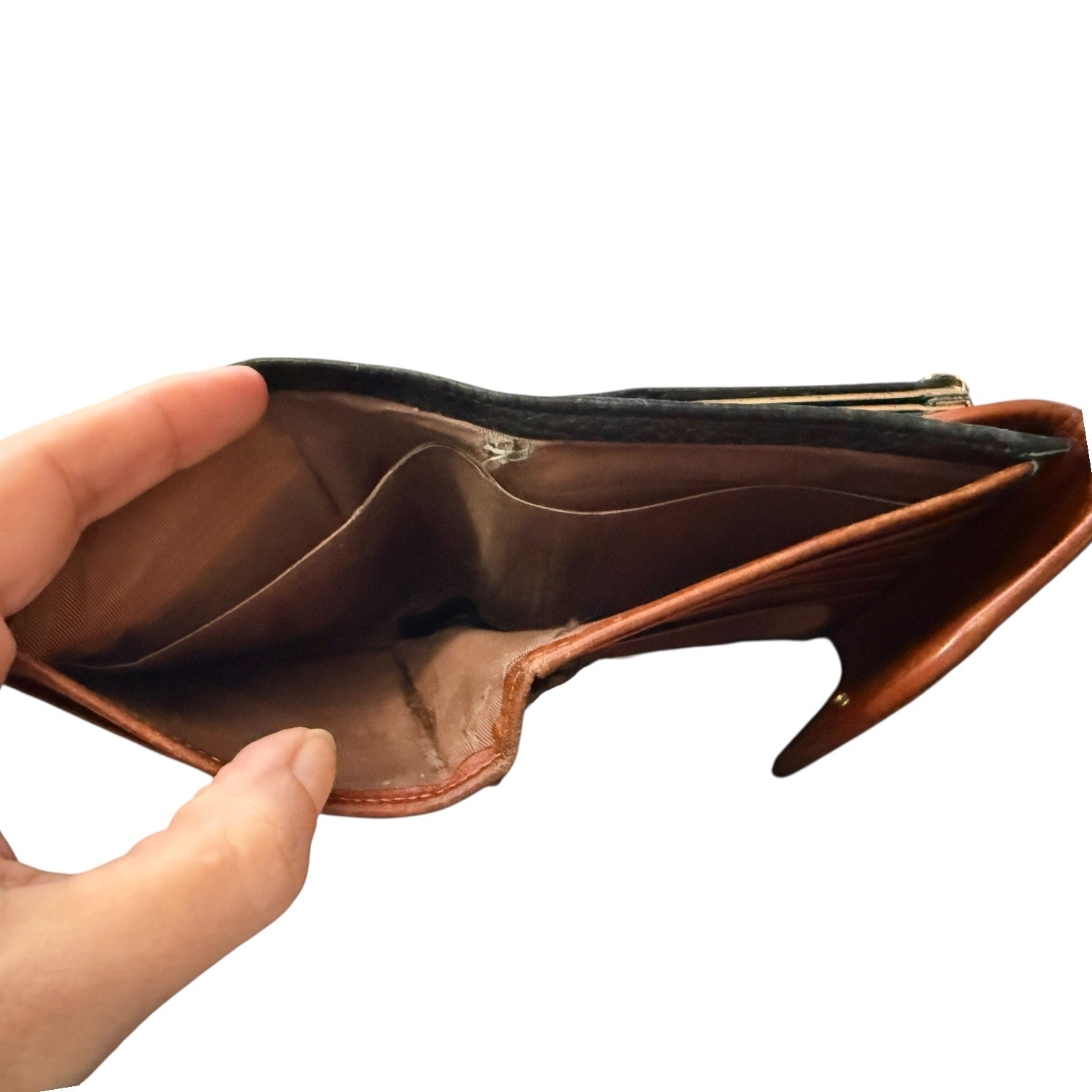 Hand holding an empty brown leather wallet on a white background