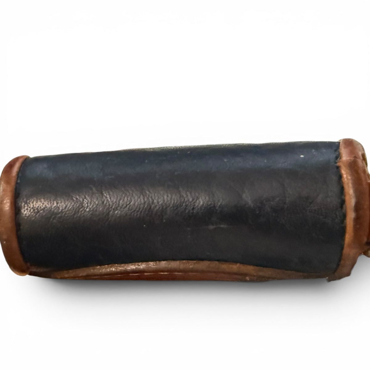 Bottom of black leather wallet with brown leather ends on a white background