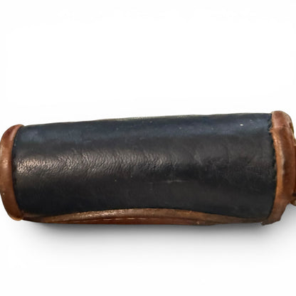 Bottom of black leather wallet with brown leather ends on a white background