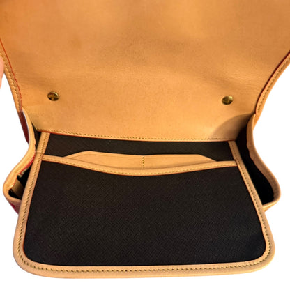 Close-up of interior of red bag with a black interior pocket on a white background