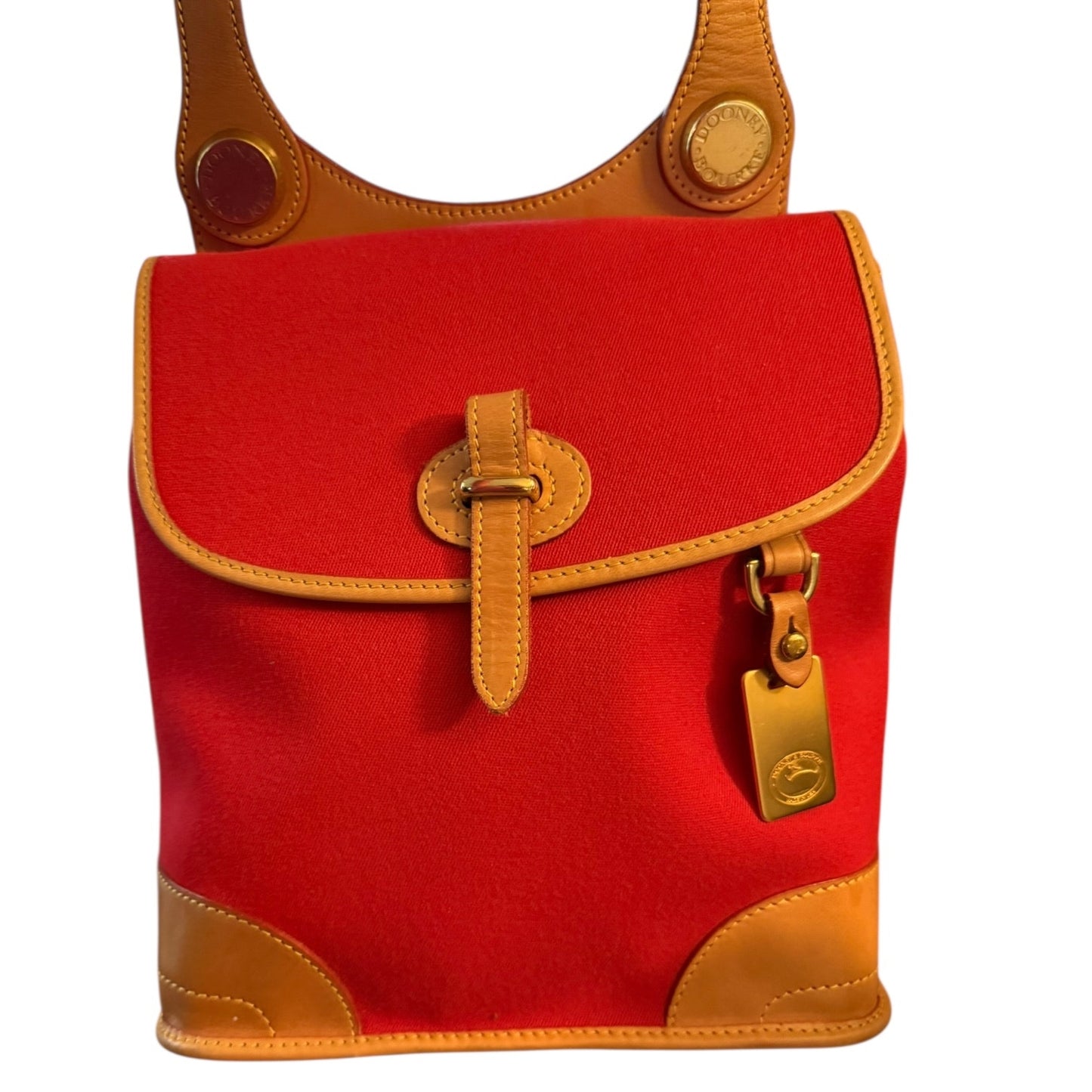 Close up of front of Red handbag with brown leather accents on a white background