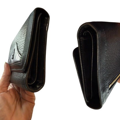 Sides of Black leather wallet held by a hand on a white background