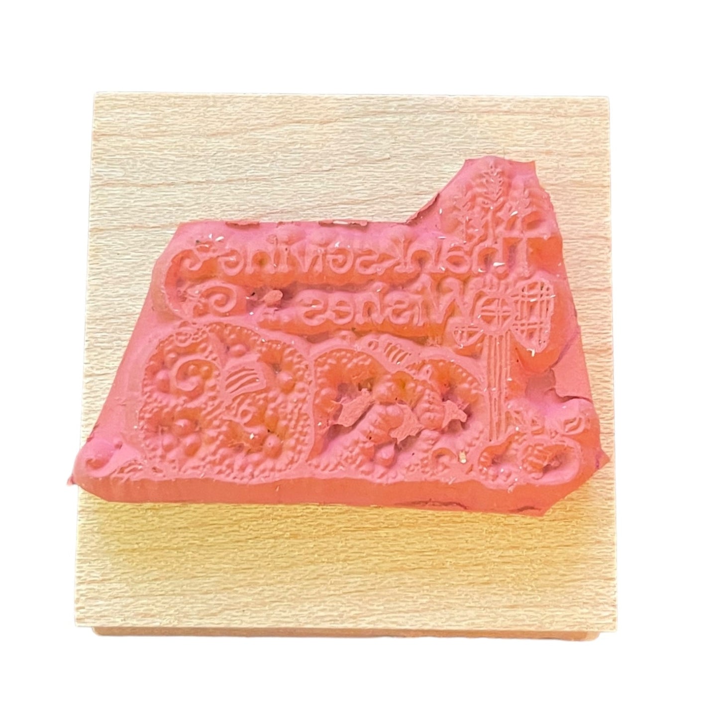 Decorative rubber stamp on a wooden block with intricate designs.