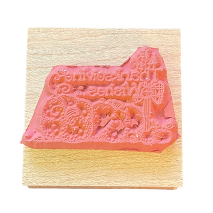 Decorative rubber stamp on a wooden block with intricate designs.