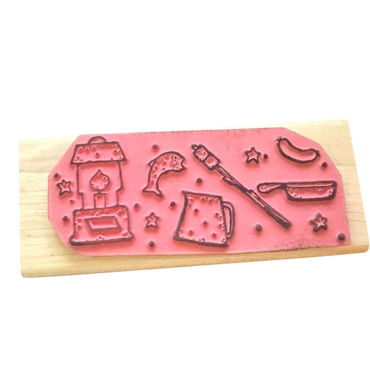 Pink stamp with various designs on a wooden block against a white background