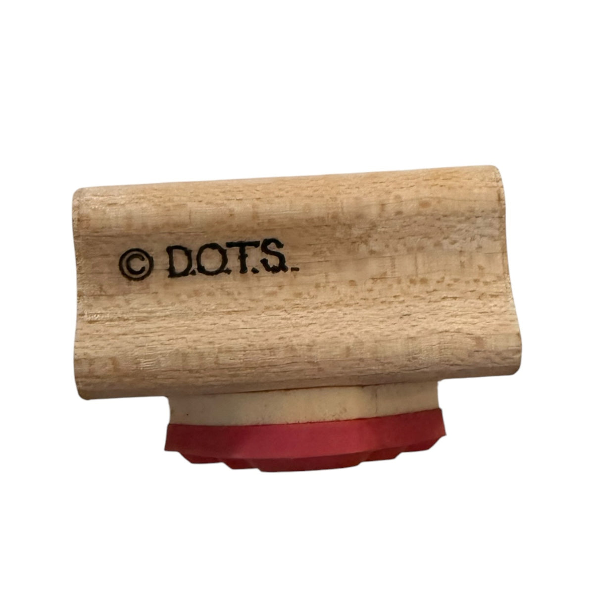 A wooden rubber stamp with the brand name D.O.T.S.