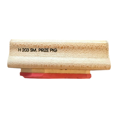 Rubber stamp labeled 'H 203 SM. PRIZE PIG' with a textured light wood , shown on a plain white background.