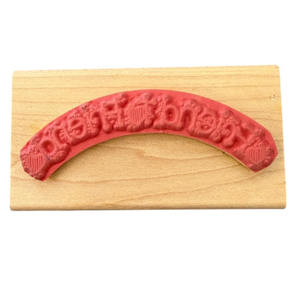 Red arch-shaped stamp on a wooden block with 'friend to friend' text